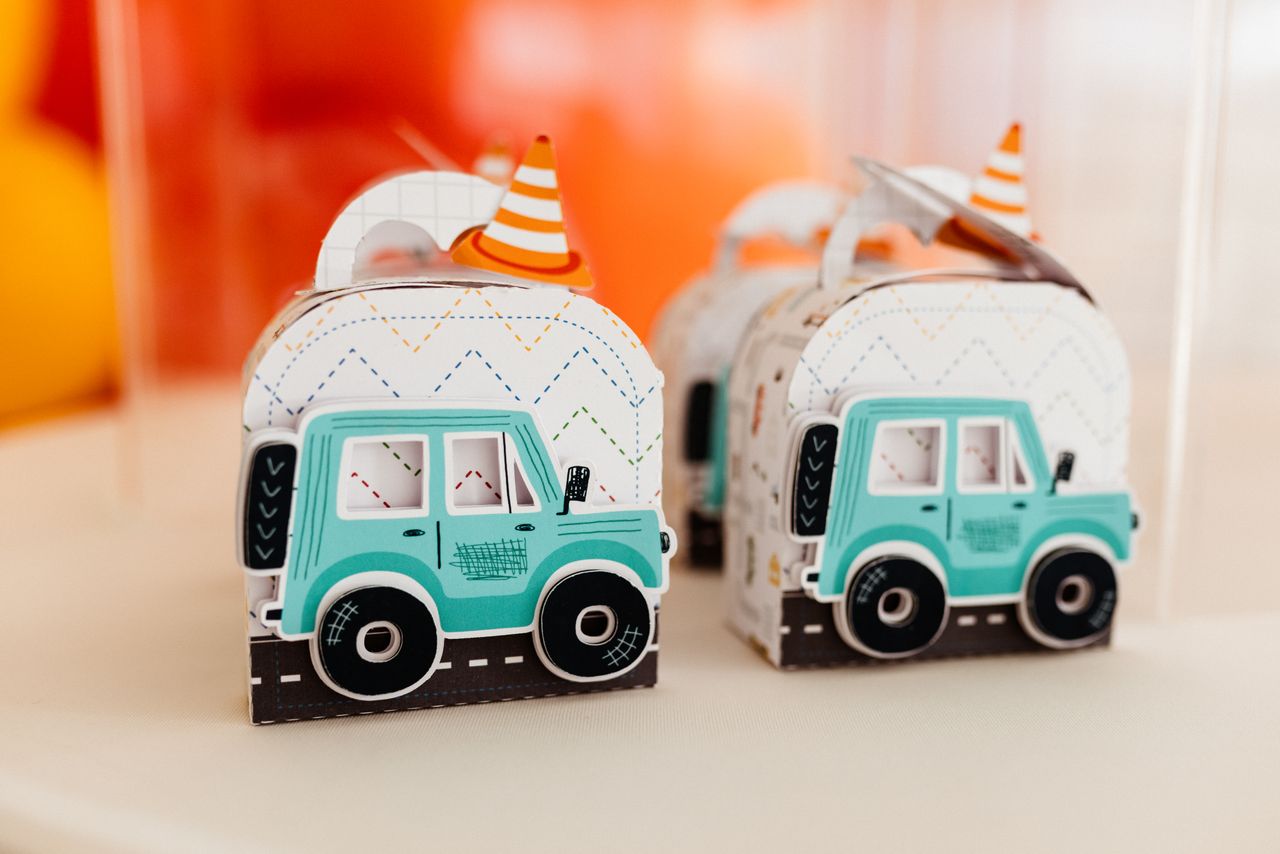 Colorful toy car-themed gift boxes with party hats, ideal for kids' birthday parties or festive events.