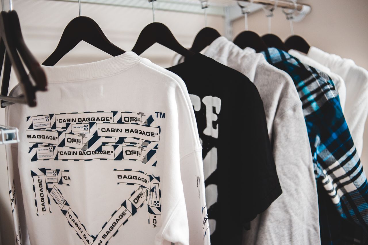 Home Assorted stylish male apparel hanging on plastic racks on metal beam in wardrobe